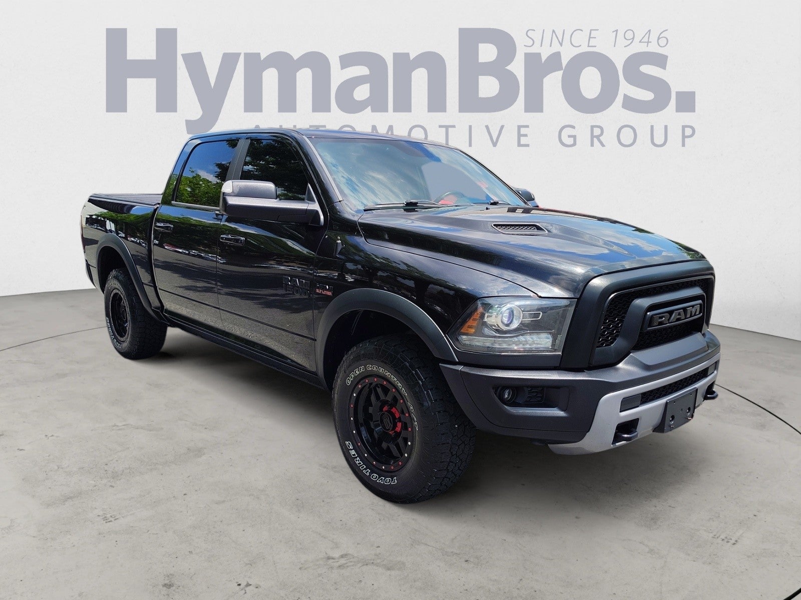 2016 RAM 1500 Rebel 4WD Crew Cab in Brilliant Black Crystal Pearlcoat — front three-quarter view